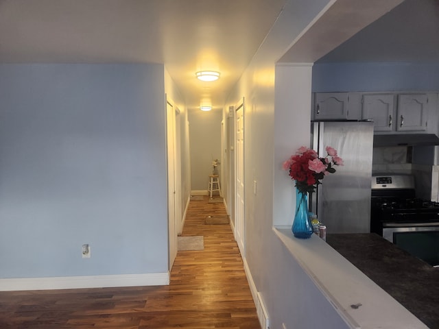 hall with light wood-style floors and baseboards