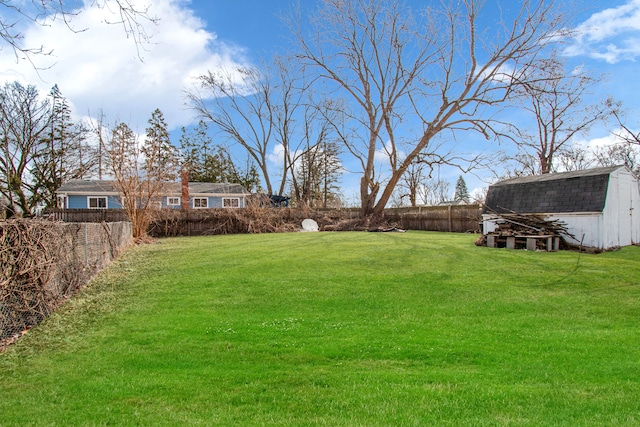 view of yard featuring an outbuilding, a fenced backyard, and a shed