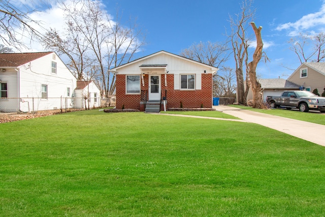 bungalow with brick siding, concrete driveway, a front yard, and fence