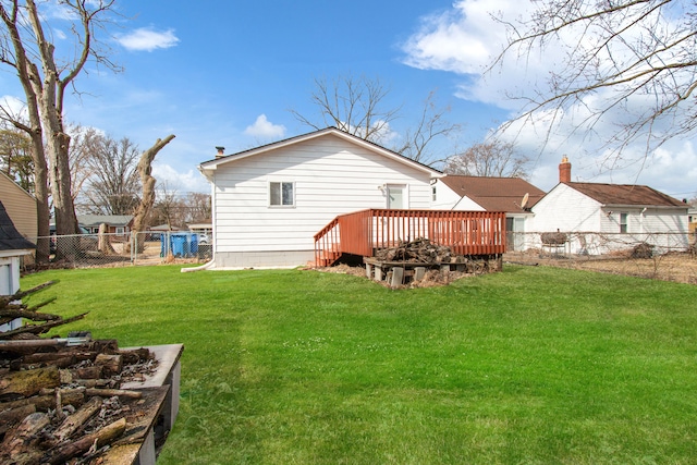 back of property with a wooden deck, a lawn, and a fenced backyard