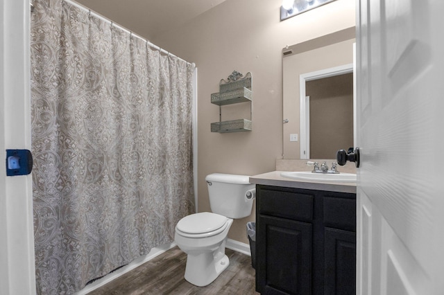 full bathroom featuring a shower with shower curtain, toilet, vanity, wood finished floors, and baseboards