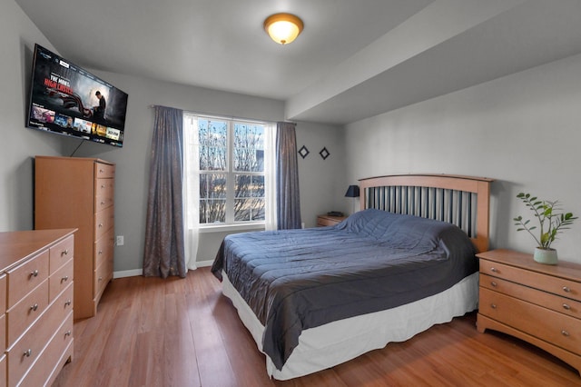 bedroom with light wood-style flooring and baseboards