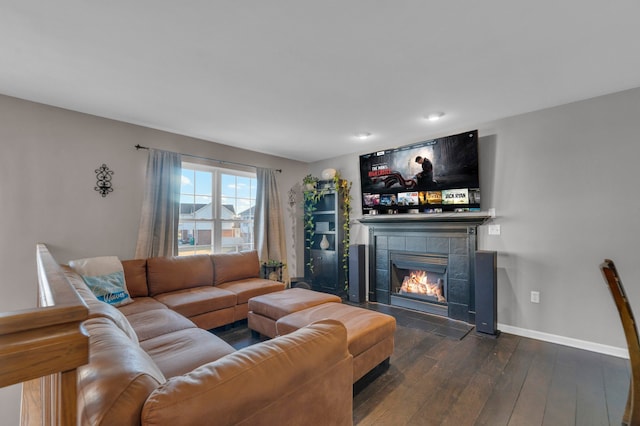 living room featuring dark wood-style floors, a fireplace, and baseboards