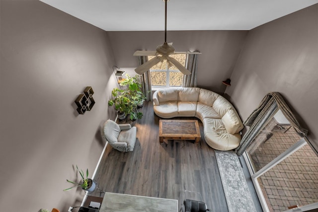 unfurnished living room featuring a ceiling fan, baseboards, and wood finished floors