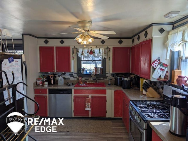 kitchen featuring decorative backsplash, dark wood-style floors, stainless steel appliances, light countertops, and a sink