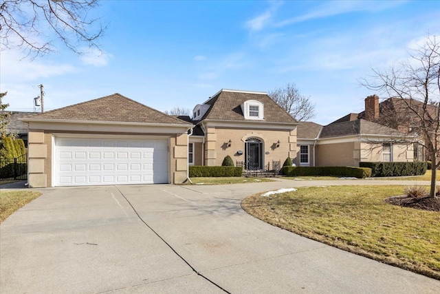 french country style house with a front lawn, driveway, and an attached garage