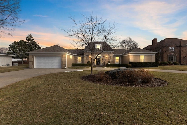 view of front of home featuring driveway, an attached garage, and a yard