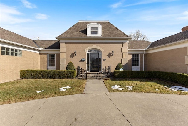 view of front of property featuring a front yard and brick siding