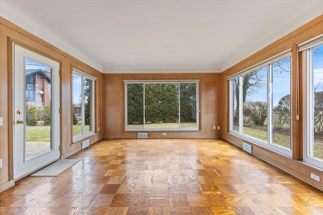 unfurnished sunroom featuring a wealth of natural light and visible vents