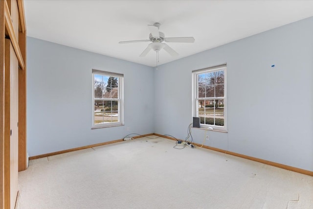 empty room with carpet floors, ceiling fan, and baseboards