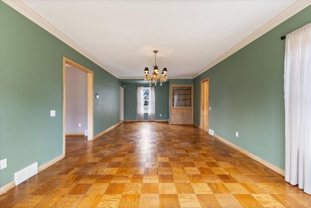 spare room with a chandelier, ornamental molding, visible vents, and baseboards