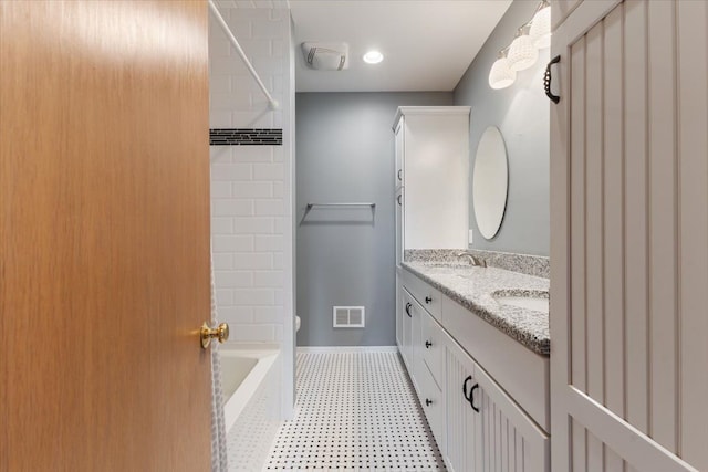 bathroom featuring toilet, a sink, visible vents, baseboards, and double vanity