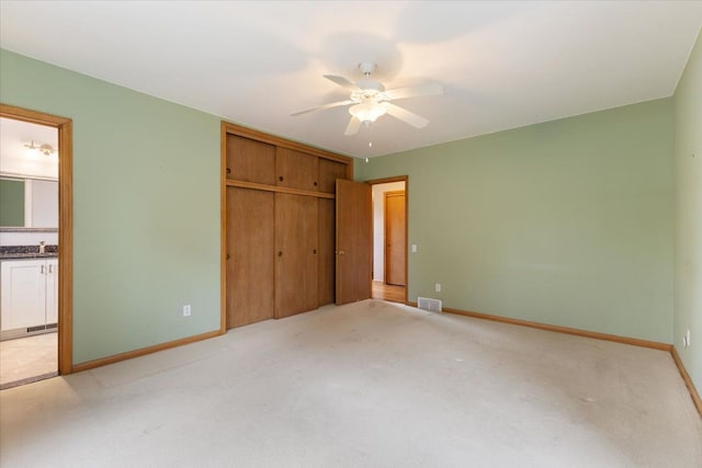 unfurnished bedroom featuring light carpet, baseboards, visible vents, and a closet