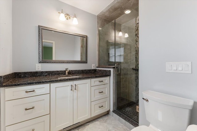 bathroom featuring toilet, a stall shower, marble finish floor, and vanity