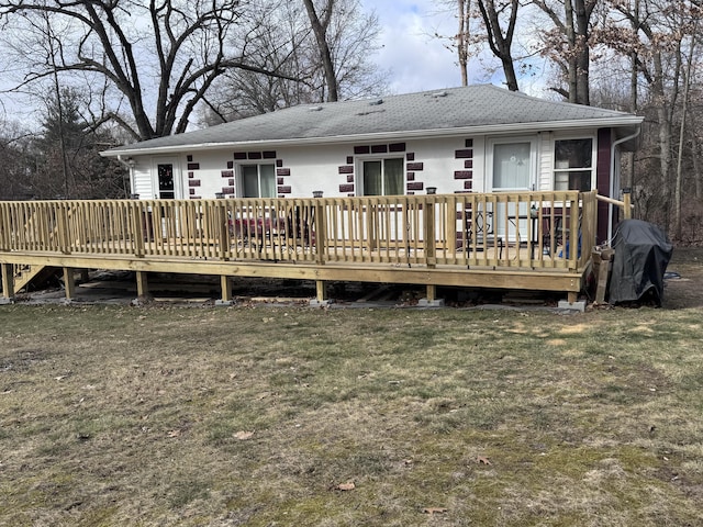 rear view of house featuring a yard and a wooden deck