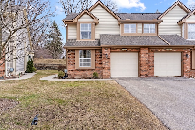 view of front of property featuring roof with shingles, a front lawn, aphalt driveway, and brick siding