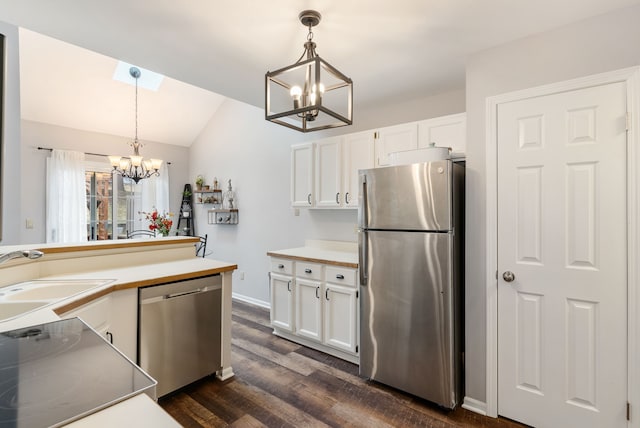 kitchen with white cabinets, appliances with stainless steel finishes, vaulted ceiling, a chandelier, and a sink