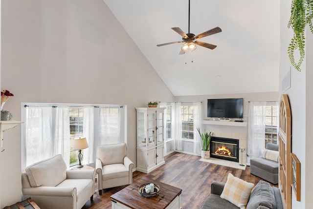 living room featuring high vaulted ceiling, a fireplace, wood finished floors, and a ceiling fan