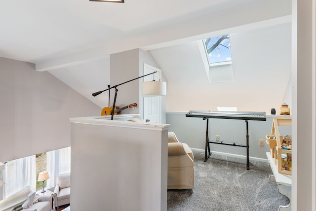 interior space with carpet floors, lofted ceiling with skylight, and baseboards