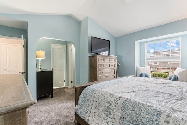 carpeted bedroom featuring arched walkways, vaulted ceiling, and baseboards