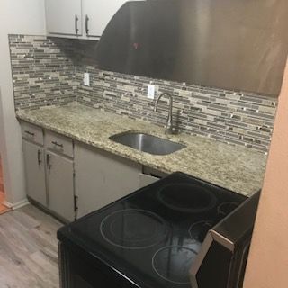 30200 Southfield Rd Unit 204, Southfield, MI 48076 - kitchen featuring black range with electric cooktop, a sink, light wood-style flooring, and decorative backsplash