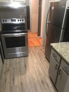 30200 Southfield Rd Unit 204, Southfield, MI 48076 - kitchen with appliances with stainless steel finishes, light wood-style flooring, gray cabinetry, and light stone counters