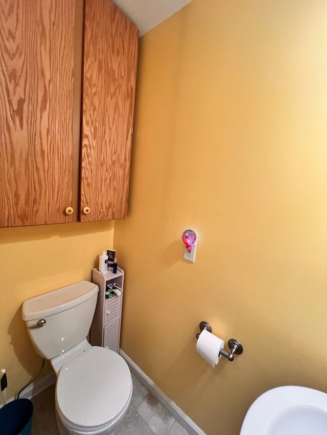 bathroom with baseboards and toilet