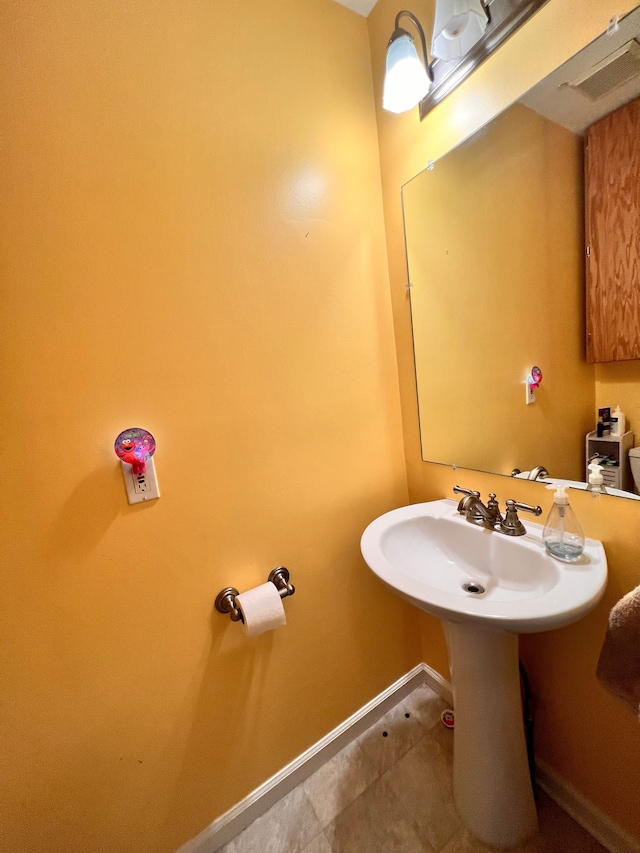 bathroom with visible vents, baseboards, and a sink