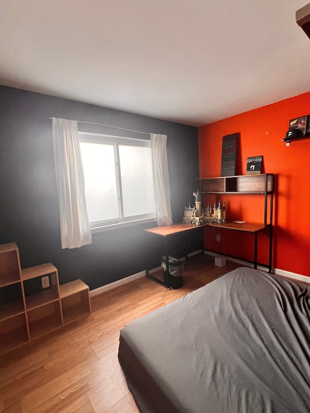 bedroom with baseboards and wood finished floors