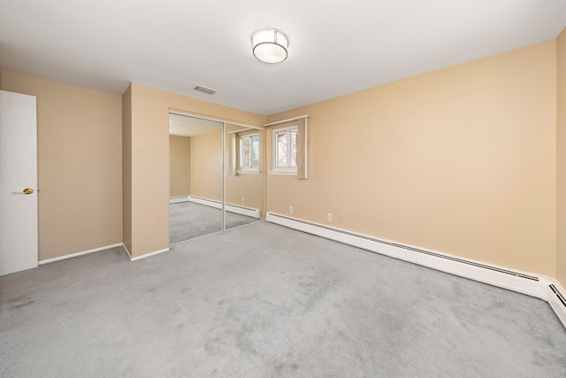 unfurnished bedroom with carpet flooring, visible vents, a closet, and a baseboard radiator