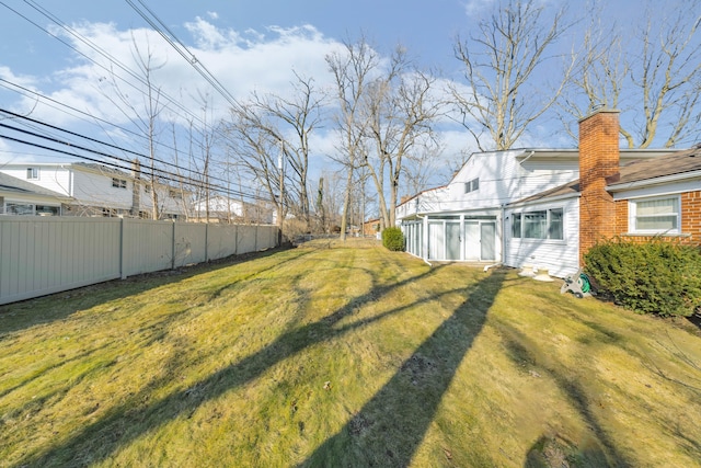 view of yard featuring a sunroom and fence