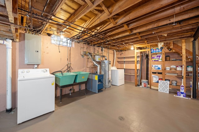 below grade area featuring electric panel, gas water heater, and independent washer and dryer