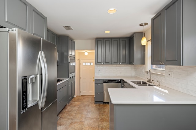 kitchen with visible vents, gray cabinetry, decorative backsplash, stainless steel appliances, and a sink