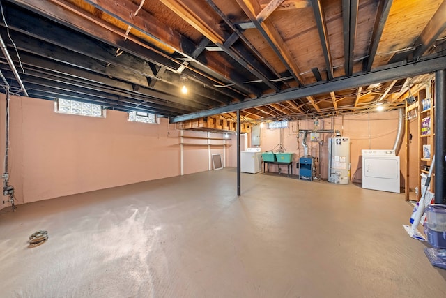 basement featuring gas water heater, electric panel, independent washer and dryer, and a sink