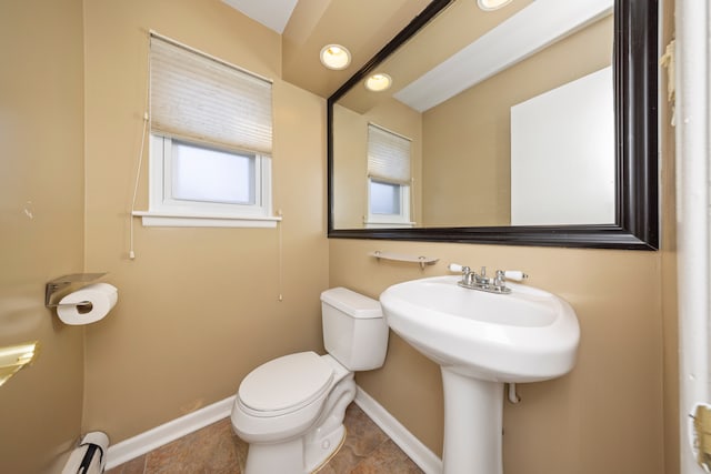 bathroom featuring a baseboard heating unit, baseboards, and toilet