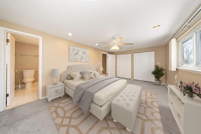 bedroom featuring multiple closets, light colored carpet, recessed lighting, ensuite bathroom, and a ceiling fan