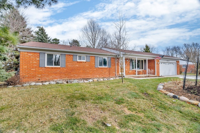 ranch-style house featuring a garage, driveway, a front yard, and brick siding