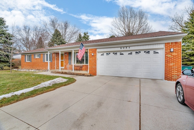 single story home with a garage, a front yard, concrete driveway, and brick siding