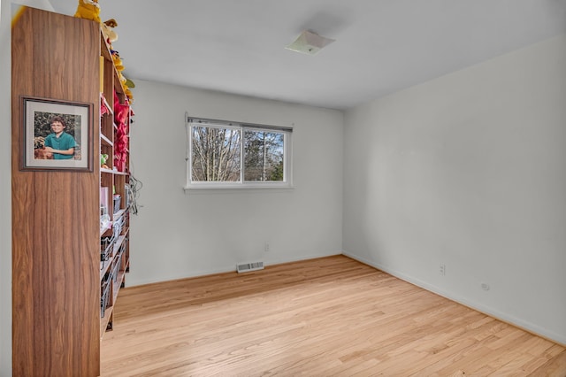 empty room featuring wood finished floors and visible vents