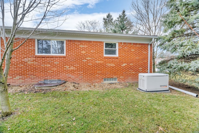 view of home's exterior with brick siding and a yard