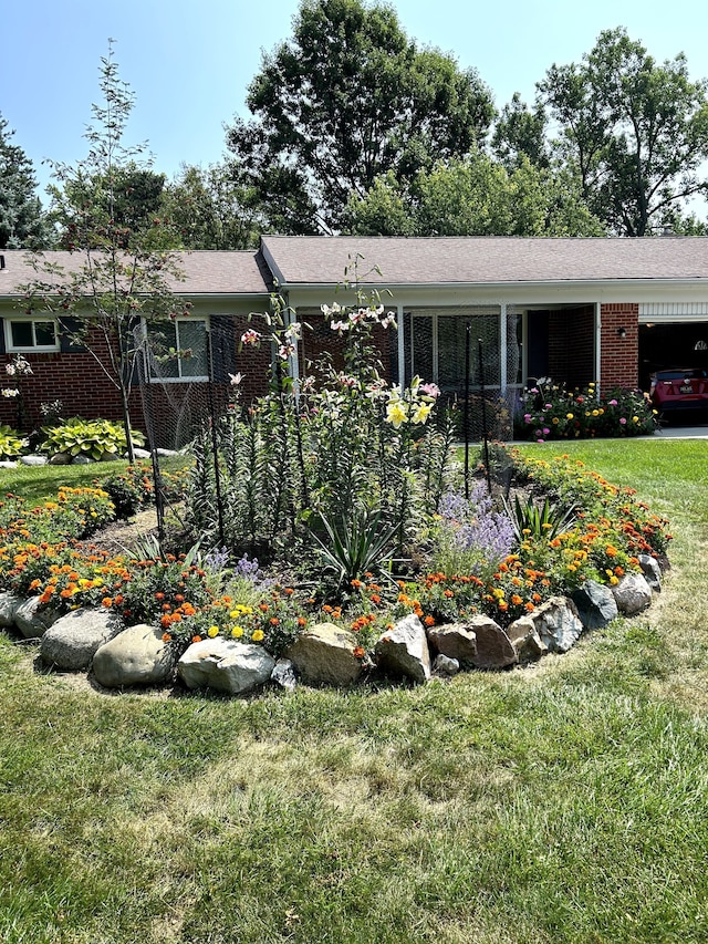 single story home featuring a front lawn and brick siding