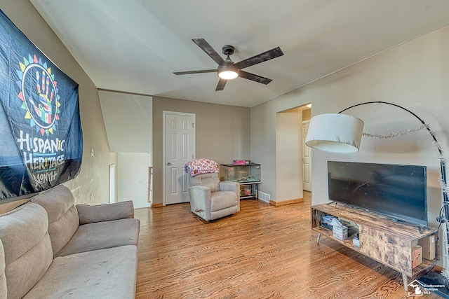 living area featuring visible vents, wood finished floors, a ceiling fan, and baseboards