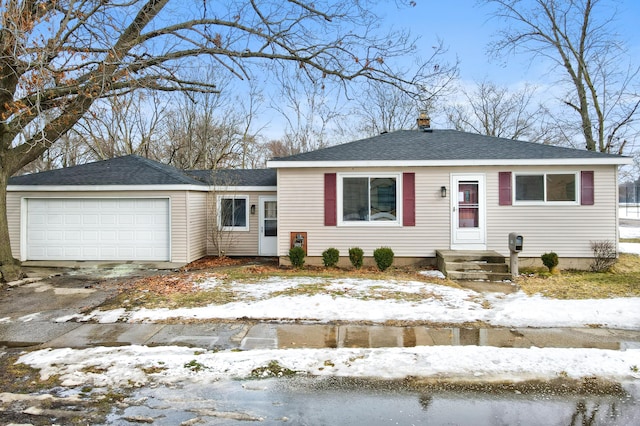 view of front of house featuring a garage, driveway, and roof with shingles