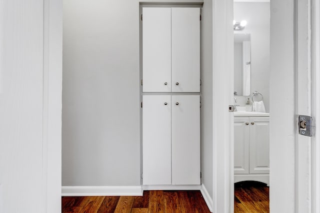 bathroom with wood finished floors, vanity, and baseboards