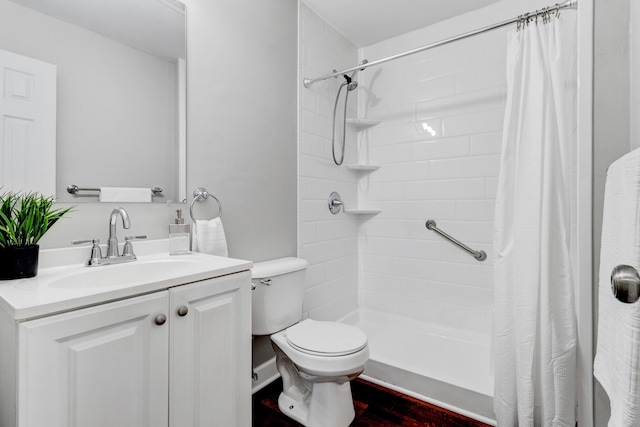 full bathroom with toilet, a tile shower, and vanity