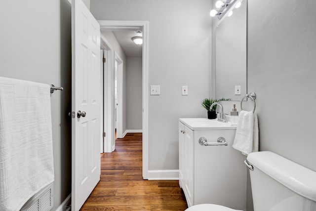 bathroom featuring vanity, wood finished floors, toilet, and baseboards