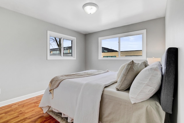 bedroom with baseboards and wood finished floors