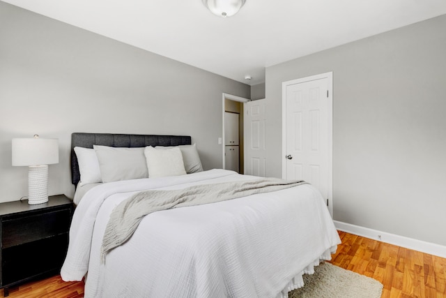 bedroom with light wood-type flooring and baseboards