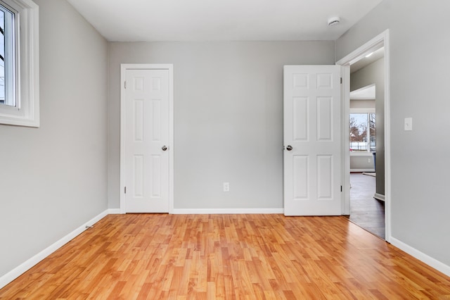 unfurnished bedroom featuring light wood-style flooring and baseboards