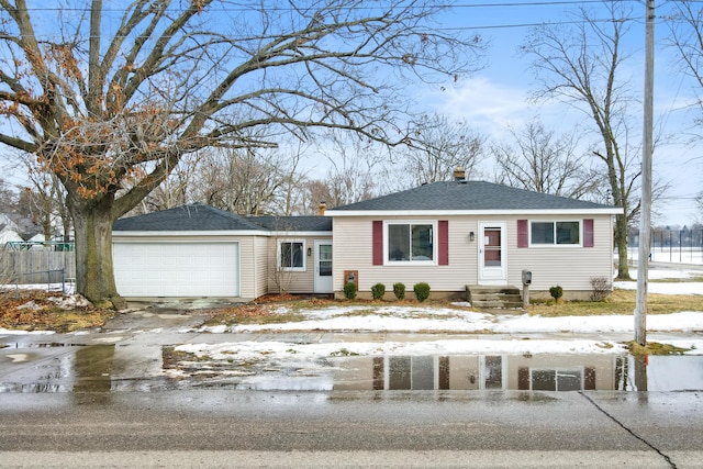 view of front of house featuring an attached garage, a shingled roof, fence, and concrete driveway